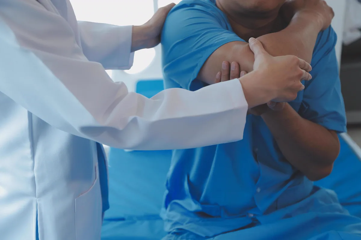 A physical therapist guiding a patient through shoulder movement