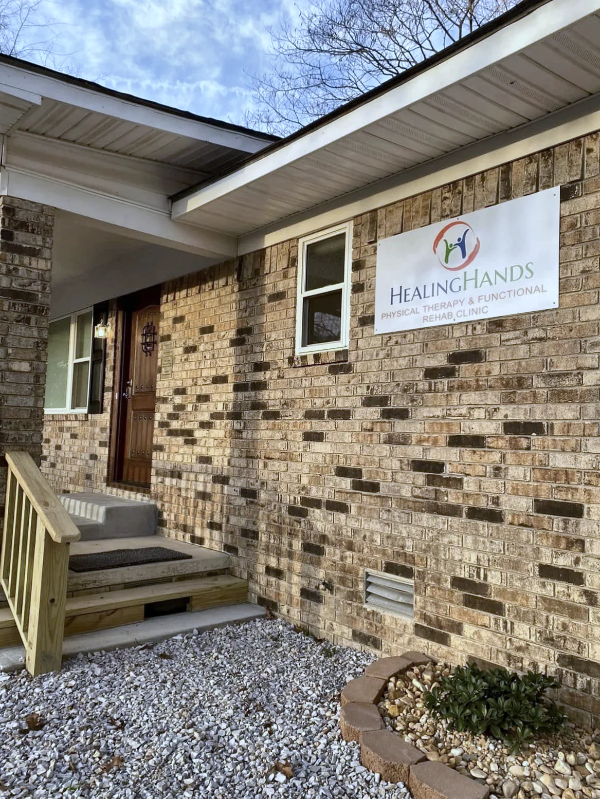 Brick front entrance with the Healing Hands sign